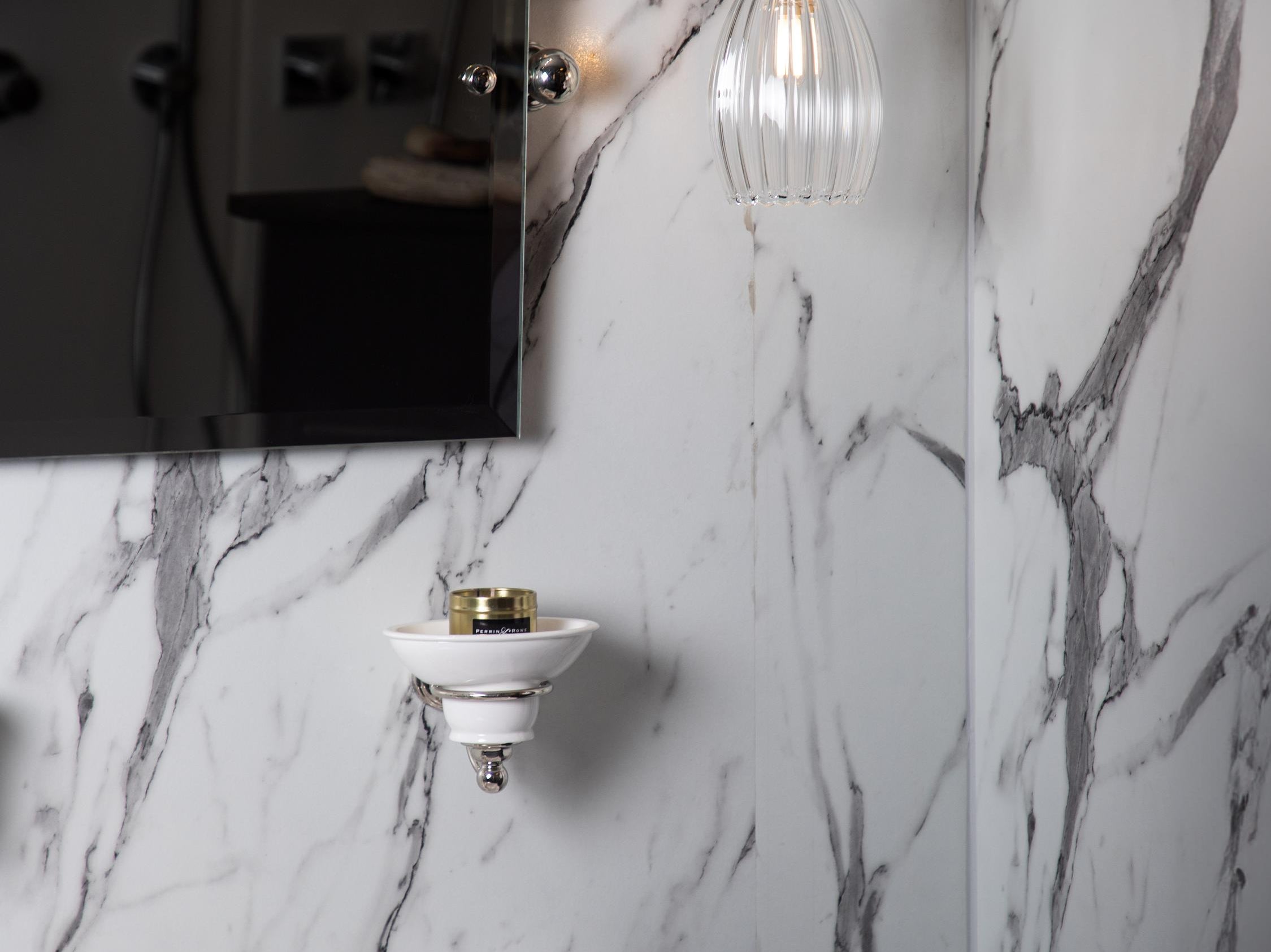 Marble bathroom featuring a small ribbed pendant light