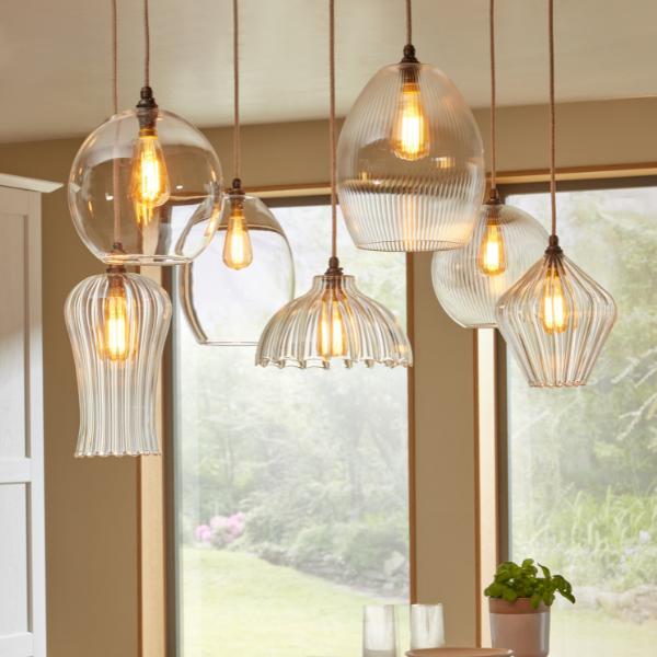 Collection of 7 hanging clear glass pendant lights in varying sizes and shapes