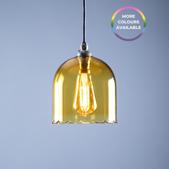 Yellow pendant light with a visible bulb against a grey background