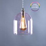 Pink glass pendant light with a visible bulb on a grey background