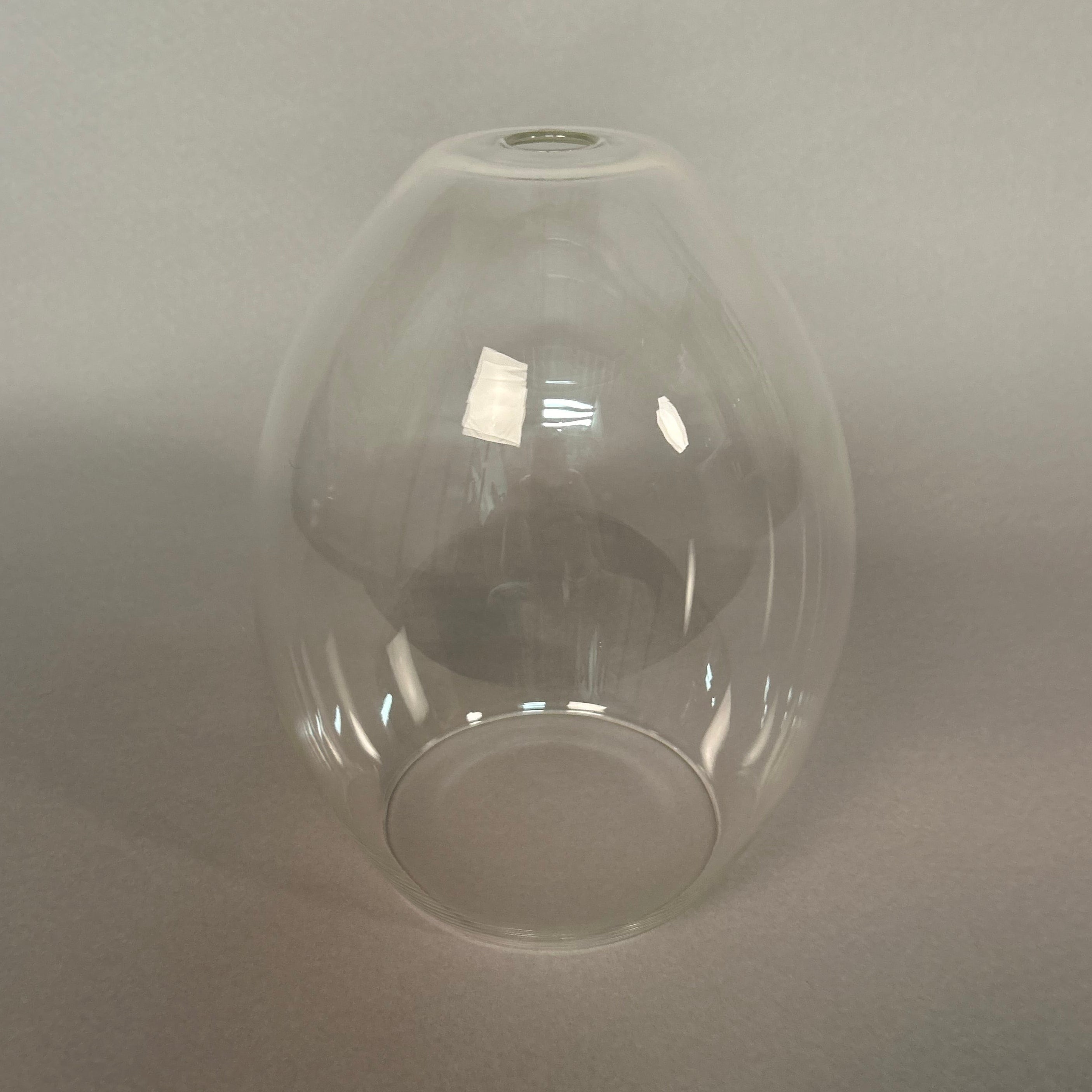 Clear glass pendant light on a grey background