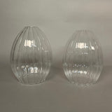 Two clear glass pendant lights with ribbed texture on a light grey background