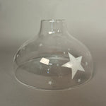 Clear glass pendant light with star designs on a grey background