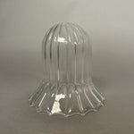 Clear glass light with ribbed design on a grey background