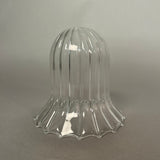 Clear glass light with ribbed design on a grey background