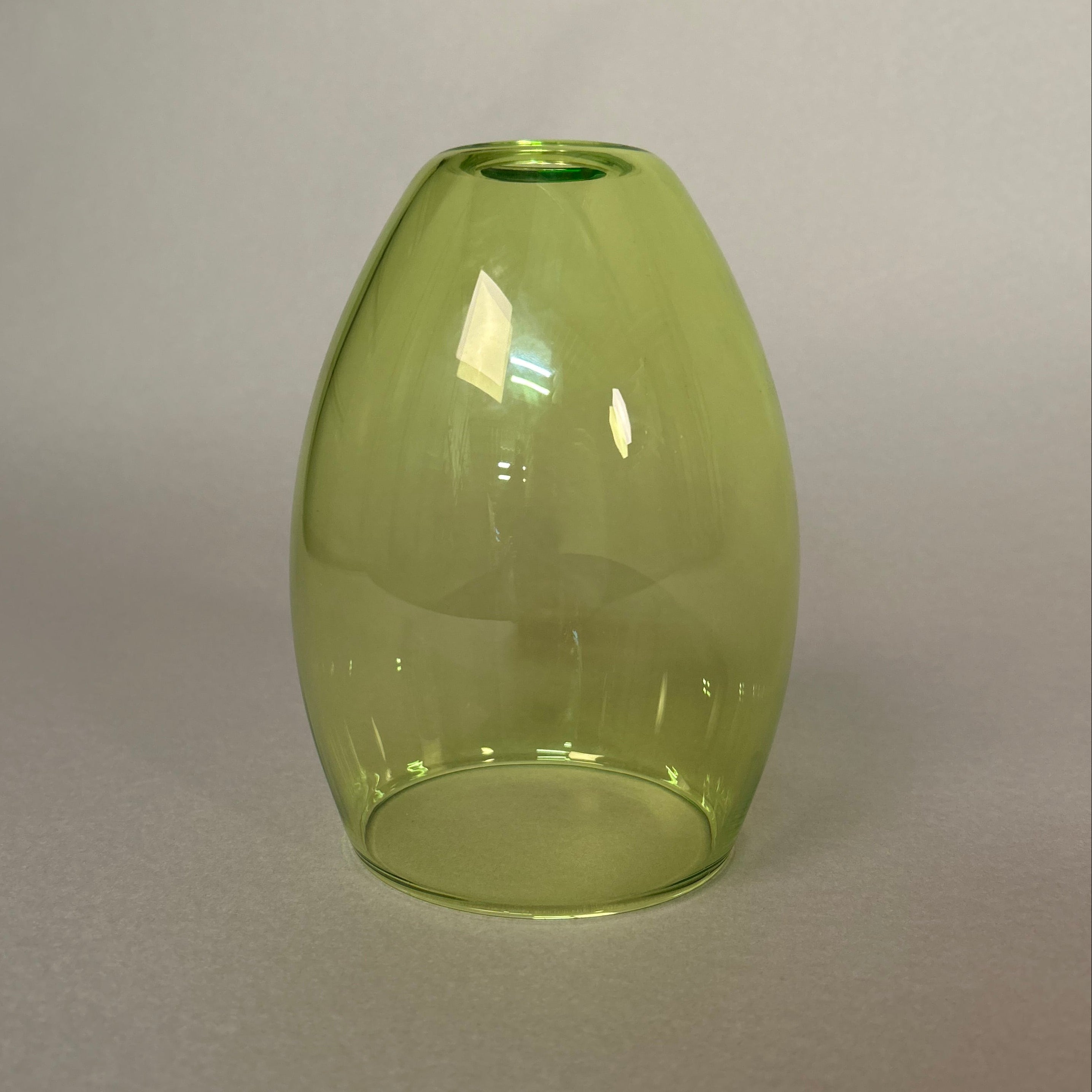 Green glass pendant light on a plain background.