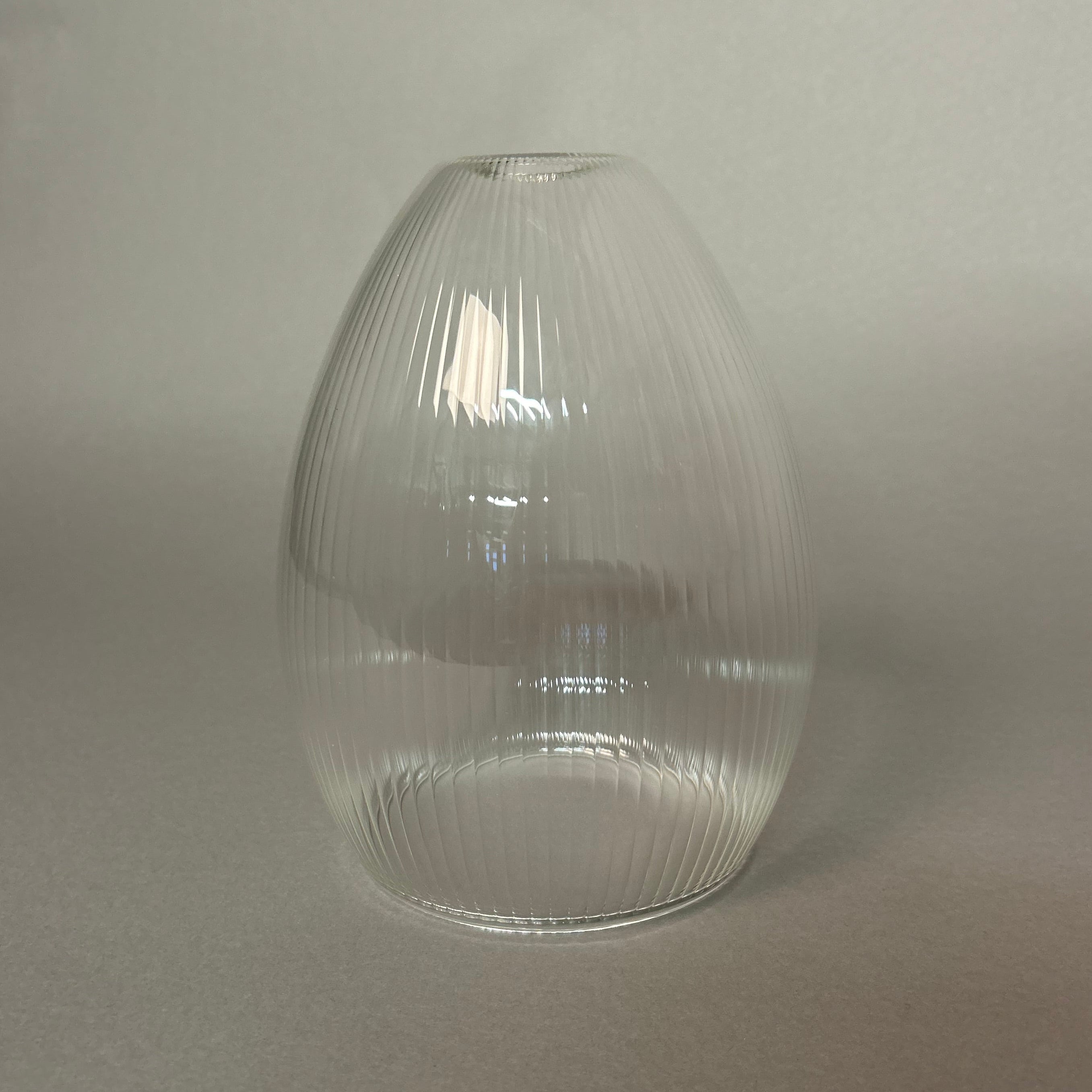 Clear ribbed glass pendant light on a light gray background