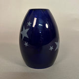 Blue glass pendant light with white star patterns on a light grey background