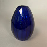 Dark blue glass pendant light on a light grey background