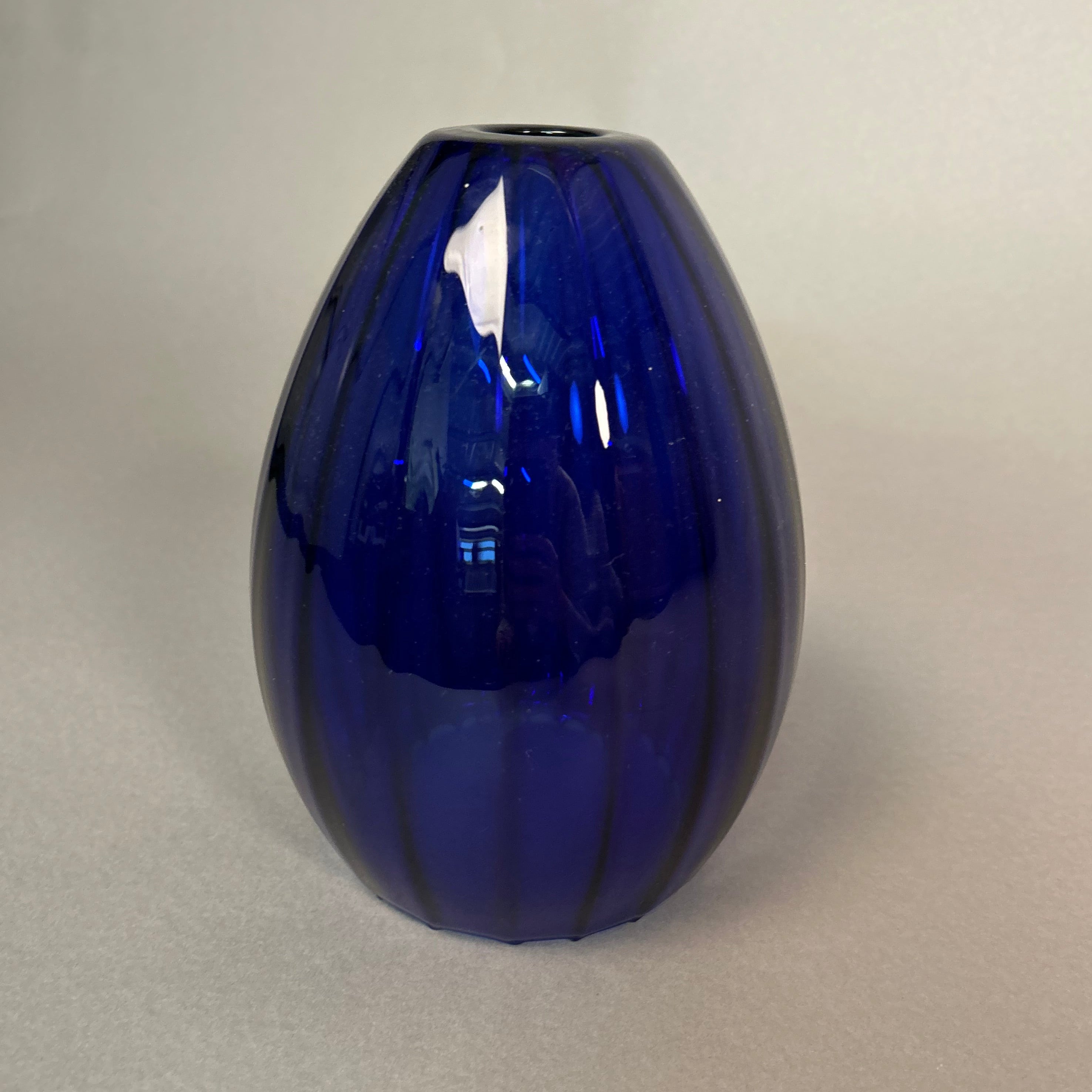 Dark blue glass pendant light on a light grey background