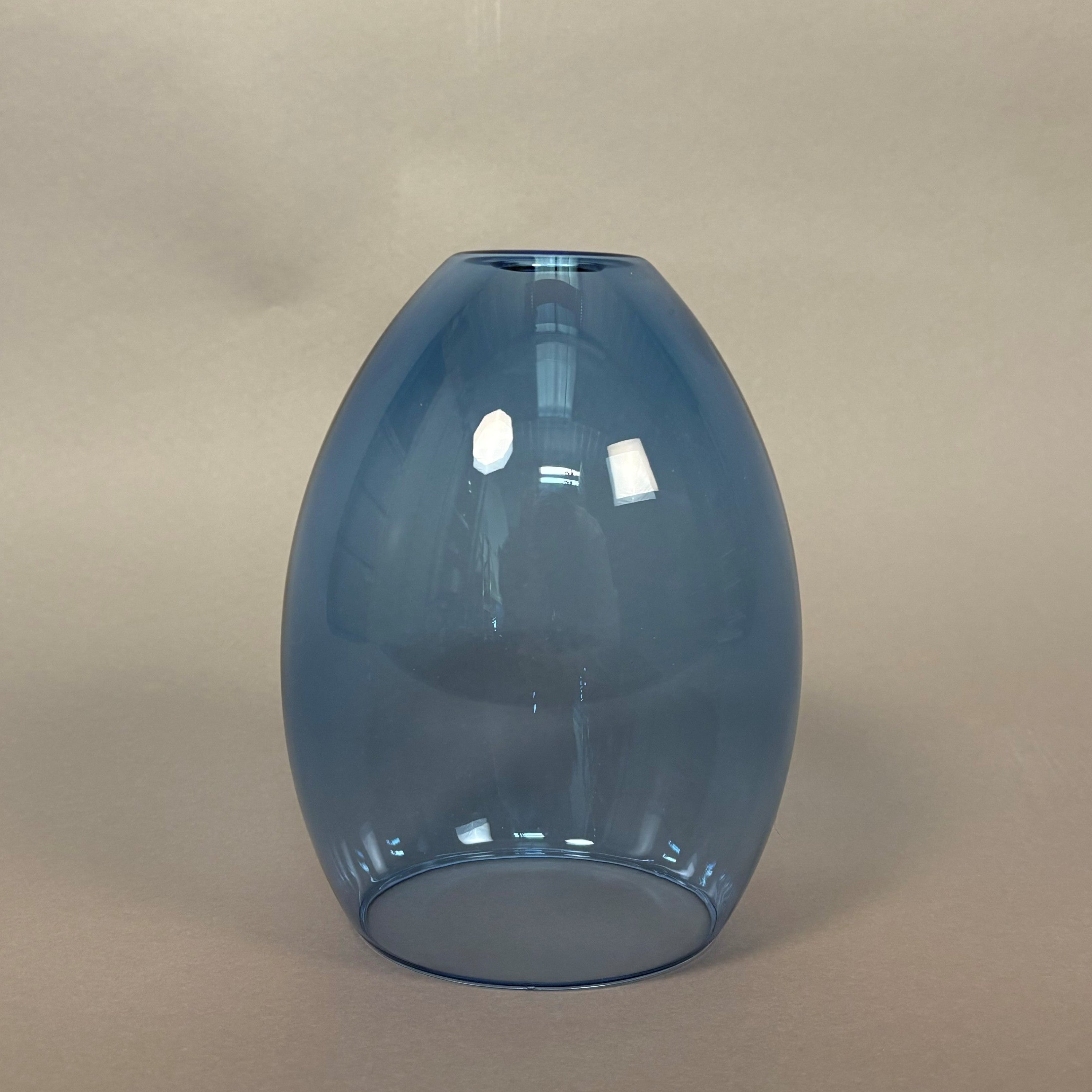Blue glass vase on a beige background