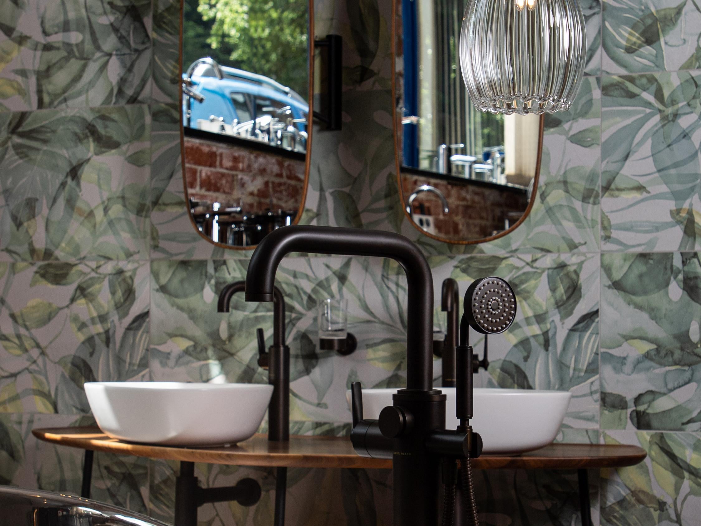 Modern bathroom featuring copper roll top bath tub and large ribbed glass pendant light