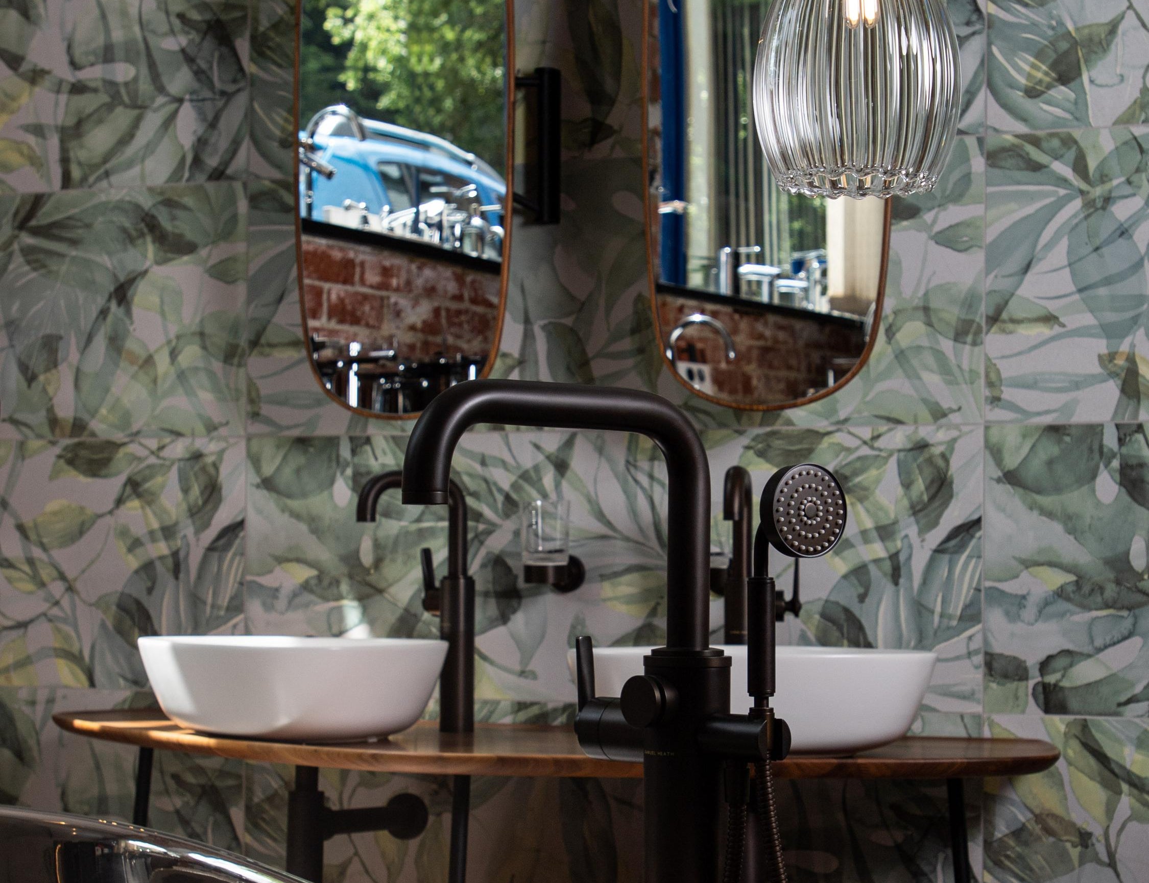 Modern bathroom featuring copper roll top bath tub and large ribbed glass pendant light