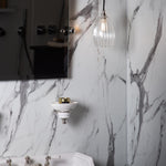 Marble bathroom featuring a small ribbed pendant light
