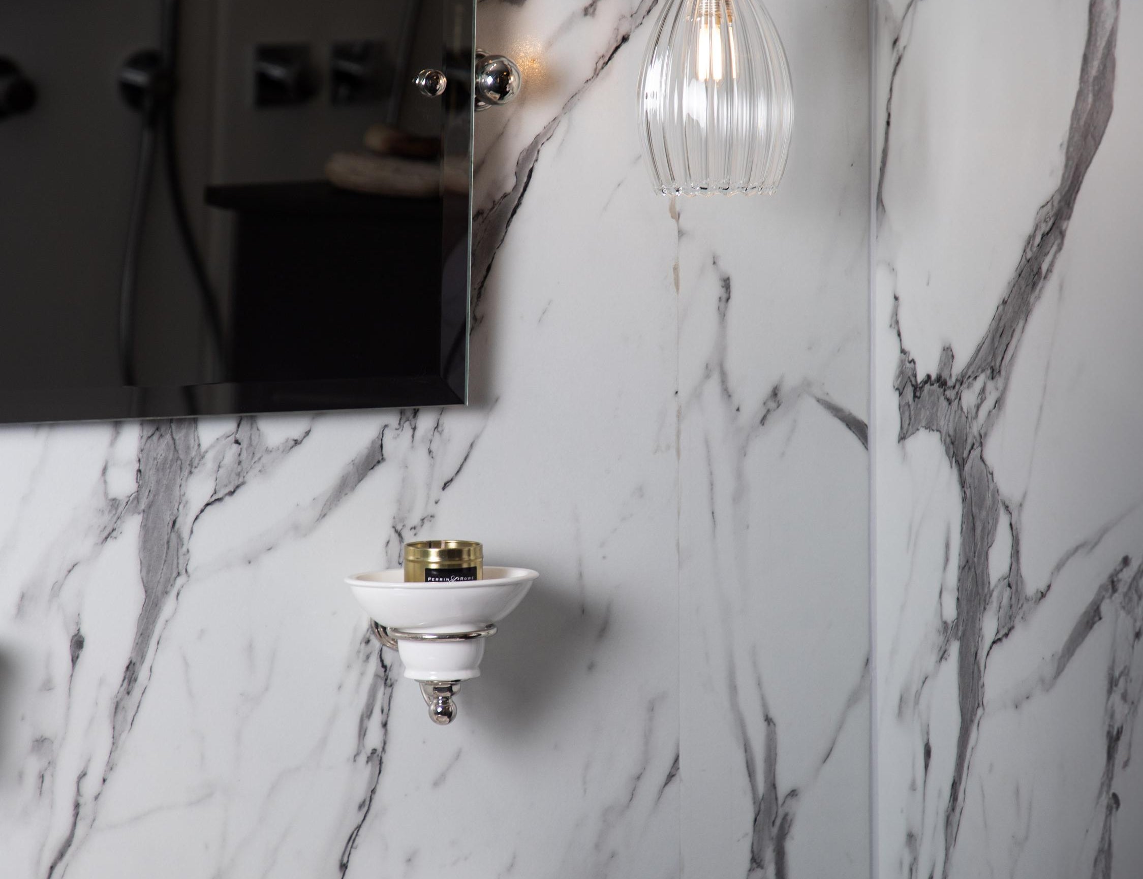 Marble bathroom featuring a small ribbed pendant light